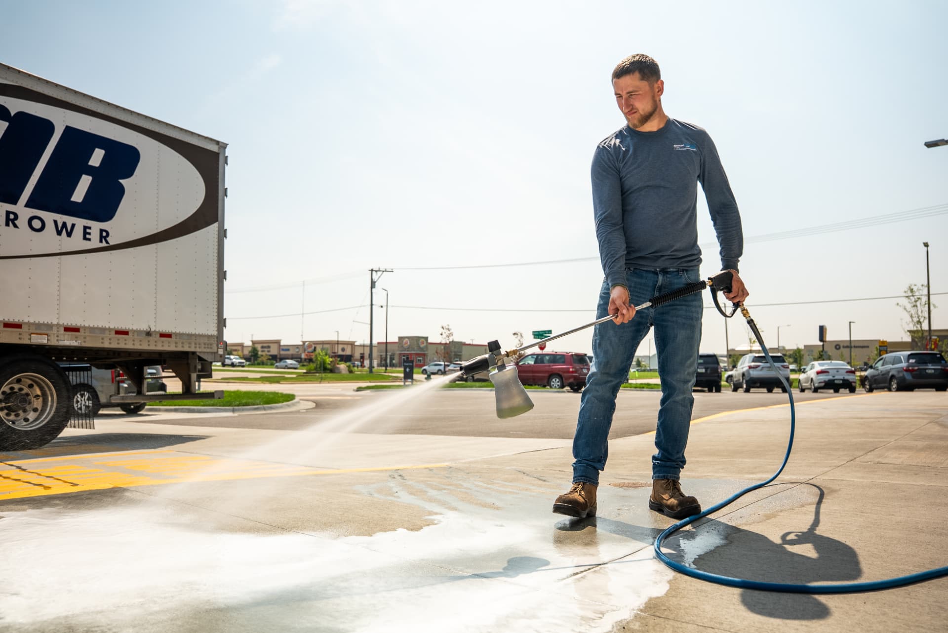 Technician applying detergent with an Easiwash foam cannon outside a restaurant